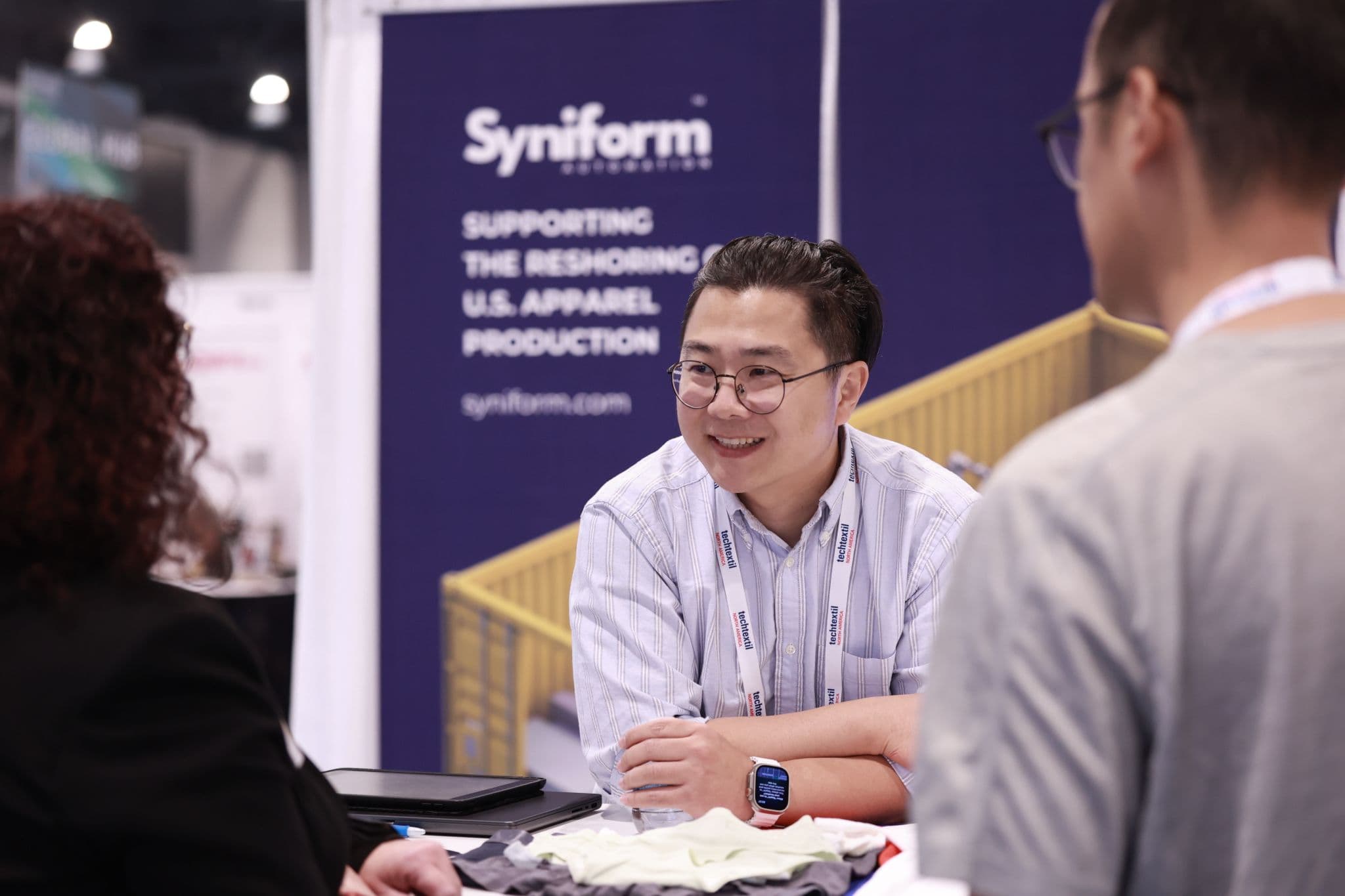 Syniform founder discussing automated apparel manufacturing with visitors at Techtextil North America 2026